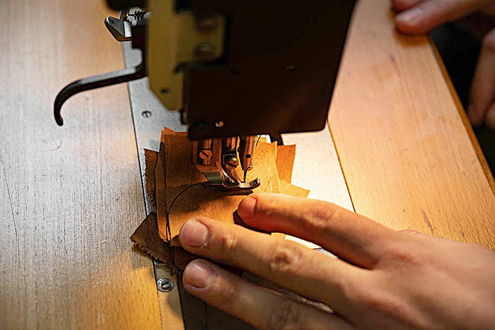 Der Taschner demonstriert, dass die Pfaff-Nähmaschine auch mit mehreren Lagen Leder zurechtkommt. - © Barbara Marko