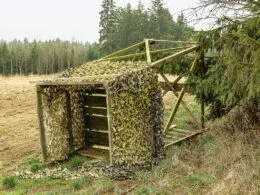 Umgestürzter Hochstand mit Tarnnetz am Waldrand – Schäden durch Wind oder mangelnde Sicherung.
