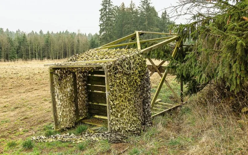 Umgestürzter Hochstand mit Tarnnetz am Waldrand – Schäden durch Wind oder mangelnde Sicherung.