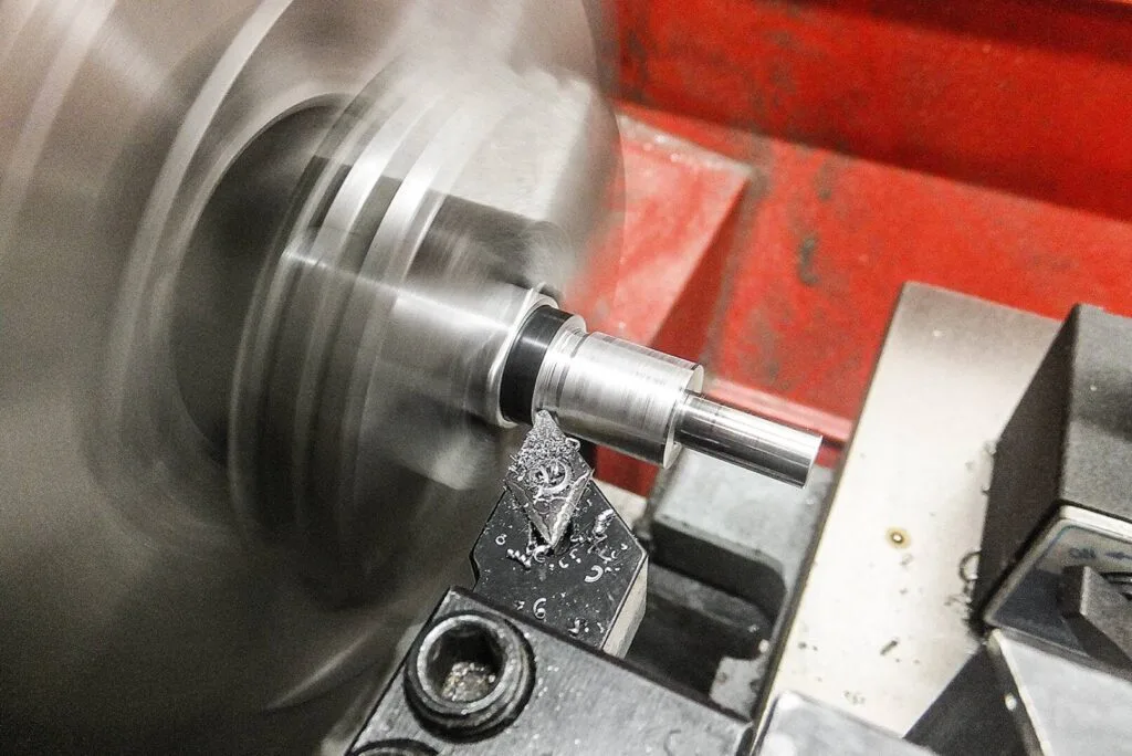 Dreharbeiten an einer Metallkomponente auf einer Drehmaschine mit hoher Geschwindigkeit in einer Werkstatt