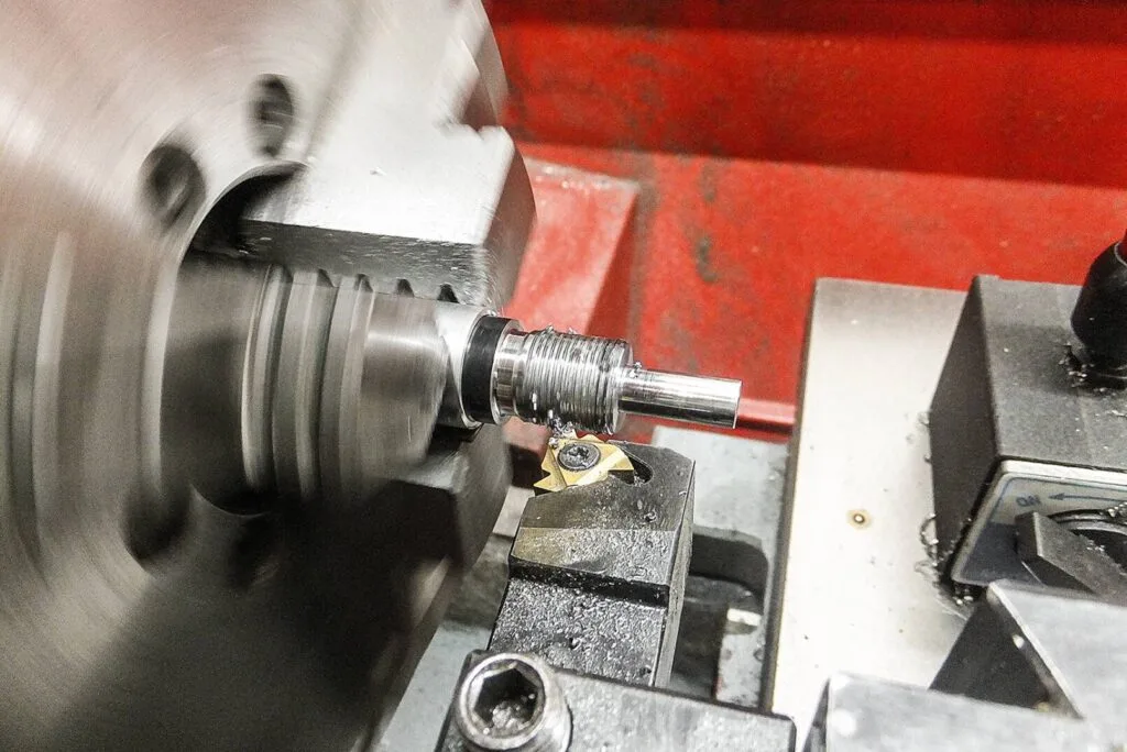 Anfertigung eines Gewindes an einem Metallbauteil auf einer Drehmaschine in einer Werkstatt