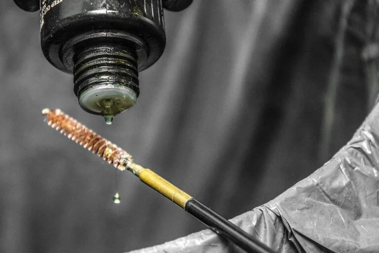 Reinigung der Waffe: Solvent auf Kaliberbürste für chemische Laufpflege aufgetragen