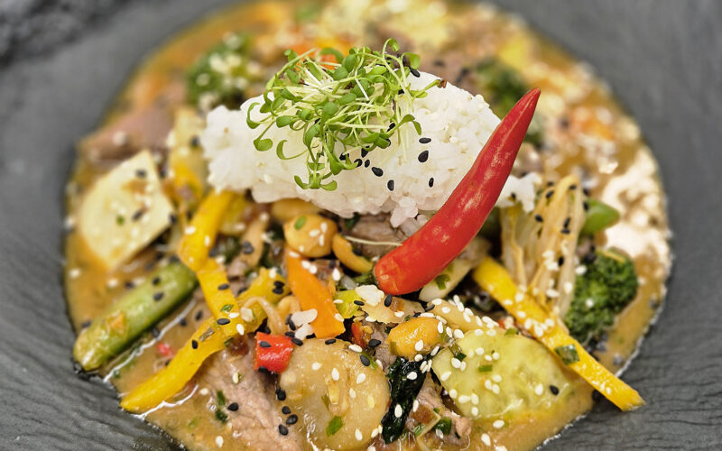 Asiatischer Wok mit Rehfleisch, Gemüse, Jasminreis und Chili dekoriert