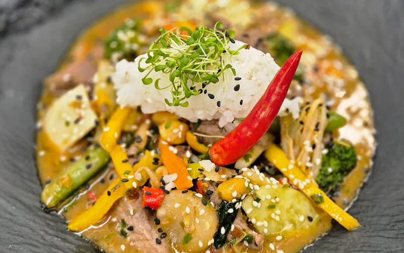 Asiatischer Wok mit Rehfleisch, Gemüse, Jasminreis und Chili dekoriert