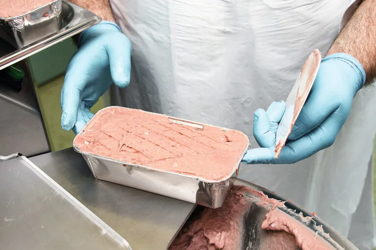 Zuletzt wird das Brät in Aluminiumschalen gefüllt; danach kommt der Leberkäse bei etwa 170 °C für 30 Minuten in den Backofen.