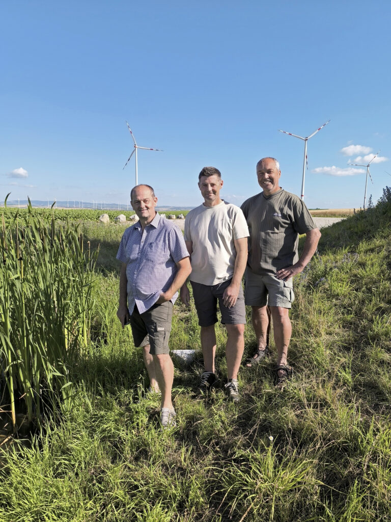 Drei Jäger stehen vor einem Windradprojekt im Revier Prinzendorf.